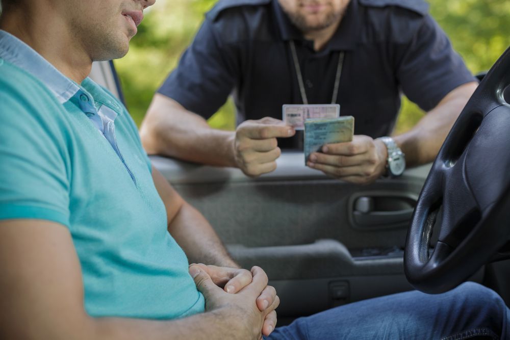 Stopped young driver with a police officer looking at his drivers license