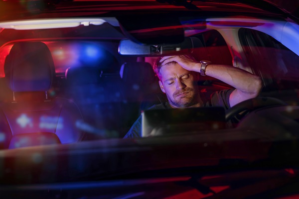 Man sitting inside a car after being stopped by police for suspicion of DUI.
